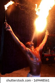 Circus fire-eater blowing a large flame from his mouth