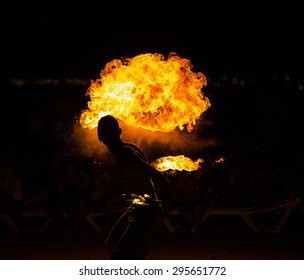 circus fire-eater blowing a large flame from his mouth