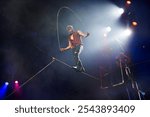 Circus performance of aerial acrobats-tightrope walkers. Tightrope walker jumps on a rope on a rope