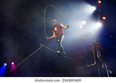 Circus performance of aerial acrobats-tightrope walkers. Tightrope walker jumps on a rope on a rope - Powered by Shutterstock