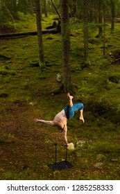 Circus Performer Doing One Arm Handstand In A Forest