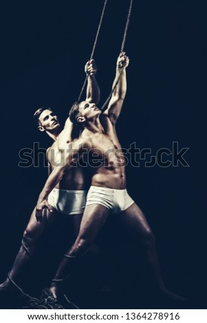 circus performers training with rope. circus show with twins men show muscular body