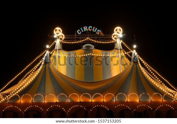 Circus tent at\
night with its colorful lights\
on