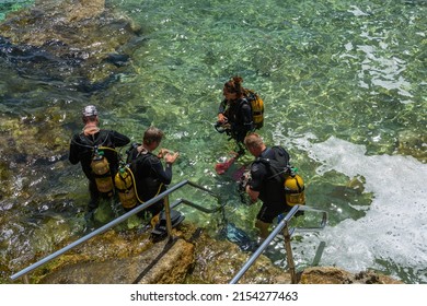 Cirkewwa, Malta - July 19th 2018: Scuba Divers Standing In The Sea Preparing For A Dive.