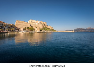 Citadel and harbour entrance at Calvi in the Balagne region of Corsica with clear blue sky and calm waters