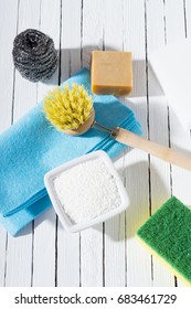 citric acid, cleaning brush, steel wool, sponges and bar of soap on white wooden table background - Shutterstock ID 683461729