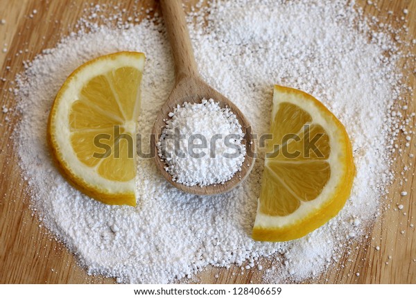 citric acid in\
wooden spoon with lemon,\
close-up