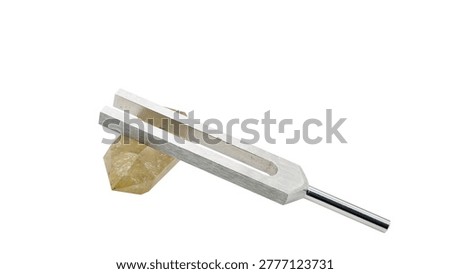 Citrine crystal and tuning fork macro isolated on white background healing tool