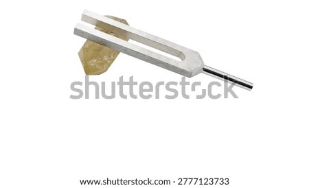 Citrine crystal and tuning fork macro isolated on white background healing tool