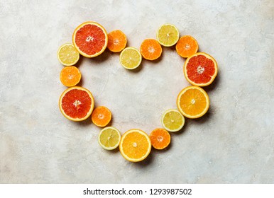 Citrus Fruit Heart Background. Different Kind Of Citrus - Orange, Grapefruit, Mandarin, Lemon Heart Shaped At Light Background. Free Space