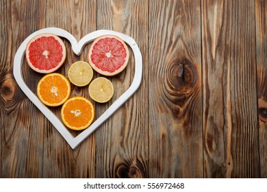 Citrus Fruit In A Heart On  Wooden Background