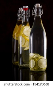 Citrus Infused Vodka In Bottles Isolated Over A Black Background