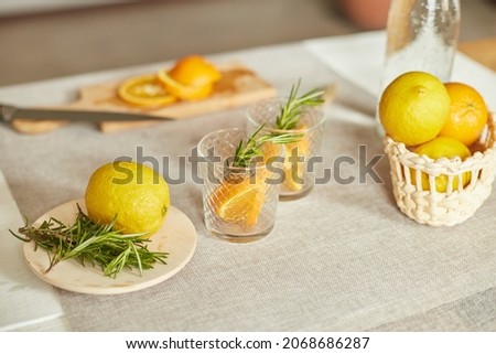 Citrus and rosemary fresh lemonade in glass on a white table at home, summer drink, detox healthy water.