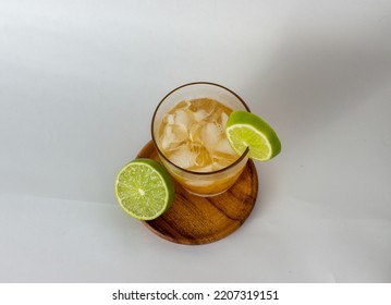 Citrus × Sinensis Drink With Ice And Citrus Limon On A Wooden Plate With White Background