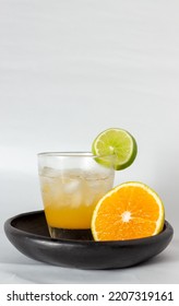 Citrus × Sinensis Drink With Ice And Citrus Limon On A Wooden Plate With White Background