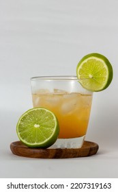 Citrus × Sinensis Drink With Ice And Citrus Limon On A Wooden Plate With White Background