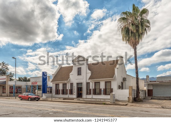 CITRUSDAL, SOUTH AFRICA, AUGUST 22, 2018: A\
street scene, with an historic bank building and a vehicle, in\
Citrusdal in the Western Cape\
Province