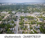 City from above, with a view of many houses and cars. The houses are spread out across the city, with some closer to the center and others further out. The cars are driving on the streets