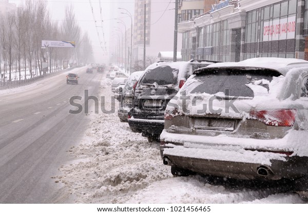 City after blizzard. Cars\
parked on a street of Kyiv covered with snow. January 12, 2018.\
Kyiv, Ukraine