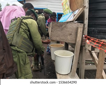 City Border Of Goma, North Kivu DR Congo 04-2019: People And Security Personell (VIrunga National Park Rangers) Are Desinfecting Their Hands With Chlorine Water To Avoid Spread Of Ebola 