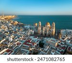 City center of Cadiz, perspective from drone. Beautiful Cathedral of Cadiz in the middle. Sunset warm colours reflecting on budlings. rooftops of Cadiz. Famous travel destination.