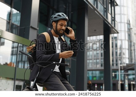 City commuter, businessman phone calling while traveling from work to home on bike. City lifestyle of single man.