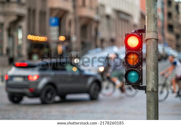 city crossing with a semaphore\
on blurred background with cars in the evening streets, red\
light