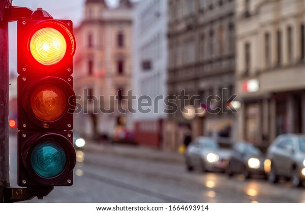 A city crossing with a semaphore. Red light in\
semaphore - image