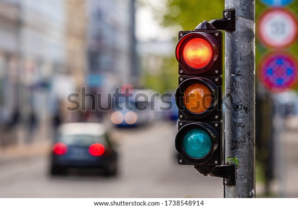 a city crossing with a\
semaphore, red light in semaphore, traffic control and regulation\
concept