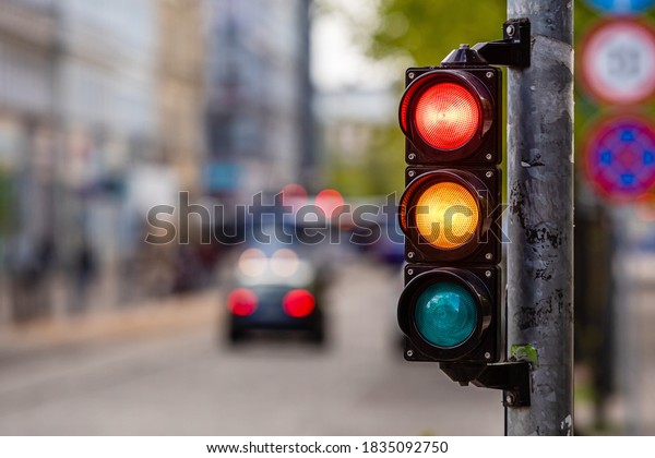 a city crossing\
with a semaphore, red and orange light in semaphore, traffic\
control and regulation\
concept