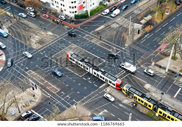 A city\
crossing with tram and cars seen from\
above.