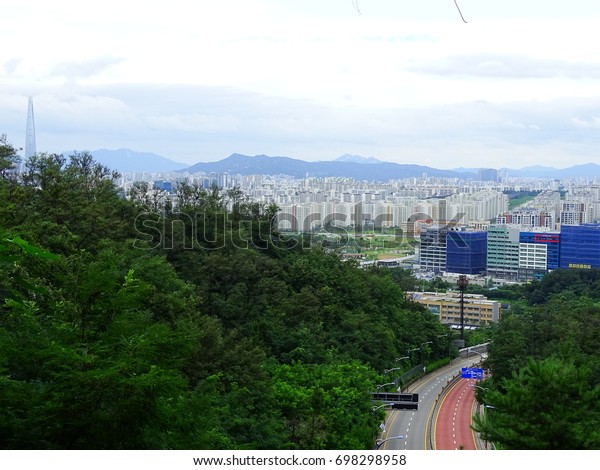 City and curved road\
in forest near Seoul