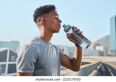 City, fitness and man drinking water after running in street, thirsty after workout in summer heat. Sun, exercise run and sweat, urban black man with healthy lifestyle and water bottle relax on road