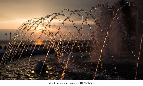 City Fountain At Sunset. Selective Focus With Shallow Depth Of Field.