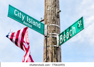 City Island Avenue and Beach street signs at intersection in Bronx, New York City, NYC with american flag