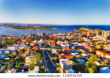 City of Newcastle in Australia north from Sydney - Hunter river mouth to Pacific ocean. CBD of industrial hub and sea port with local streets and houses around the Cathedral of Newcastle.