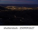 City at night with curvy mountain road long exposure headlights California