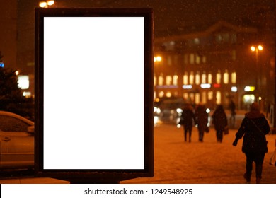 City Outdoor Billboard Mockup Winter City With Snow Going. Glows In The Darkness Of The Night City.