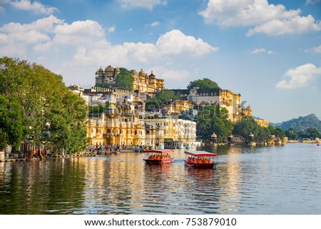 
City Palace and tourist boat on lake Pichola. Udaipur, Rajasthan, India