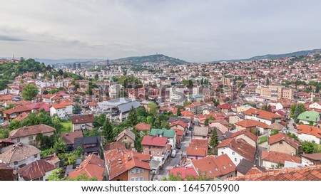 City panorama with cable car moving up and down from Sarajevo station to mountains, Bosnia And Herzegovina . Houses with red roofs