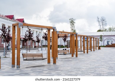 The City Park On The Square, Beautiful Swings Made Of Wood, Hanging Benches On Chains, A Place For People To Relax, A Modern Recreation Center For Citizens, There Are No People. High Quality Photo