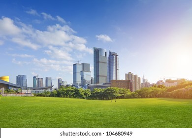 City Park Under Blue Sky With Downtown Skyline In The Background