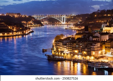 City of Porto and Gaia at night by the Douro river in Portugal, Arrabida Bridge at the far end.