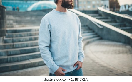 City portrait of handsome hipster guy with beard wearing gray blank hoodie or hoody and hat with space for your logo or design. Mockup for print - Powered by Shutterstock