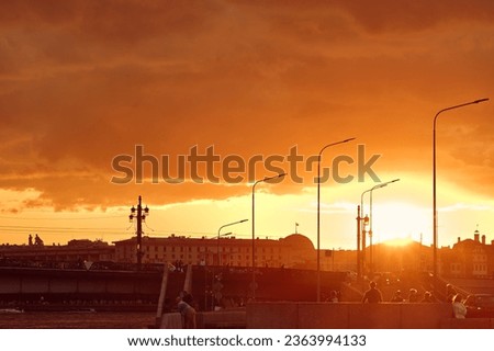 City in the rays of the sun at sunset. Colorful evening sky over the city. Silhouettes of people in backlight from sunlight.