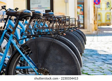 City rental bicycles station in an urban area with paved road with cobblestone - Powered by Shutterstock