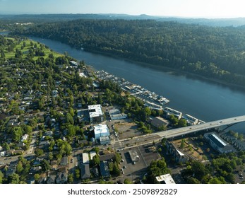 A city with a river running through it and a bridge over it. The bridge is a large structure that spans the width of the river. The city is surrounded by trees and has a peaceful, serene atmosphere - Powered by Shutterstock