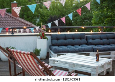 City Rooftop Terrace With Palette Furniture, Herbal Garden And Bunting Flags