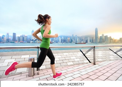 City Running - Woman Runner And Hong Kong Skyline. Female Athlete Fitness Athlete Jogging Training Living Healthy Lifestyle On Tsim Sha Tsui Promenade And Avenue Of Stars In Victoria Harbour, Kowloon.