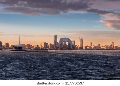 City Skyline In Golden Sunset Light And Sea With Waves Due To Strong Wind, Baku, Azerbaijan